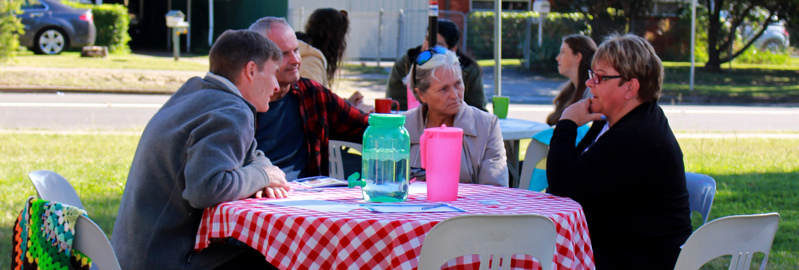 Group of people chatting at a table outdoors
