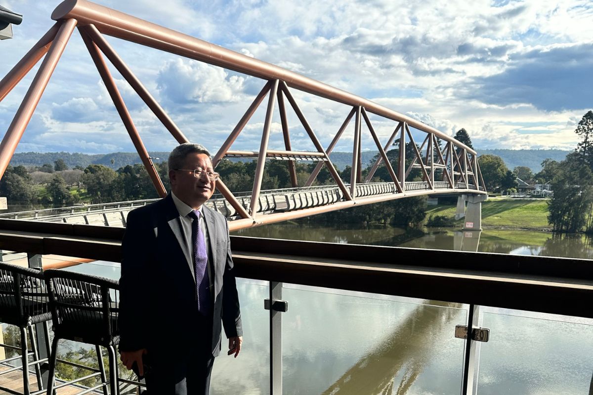 man overlooking bridge across river