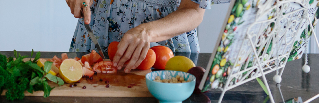 someone cutting tomatoes to a receipe