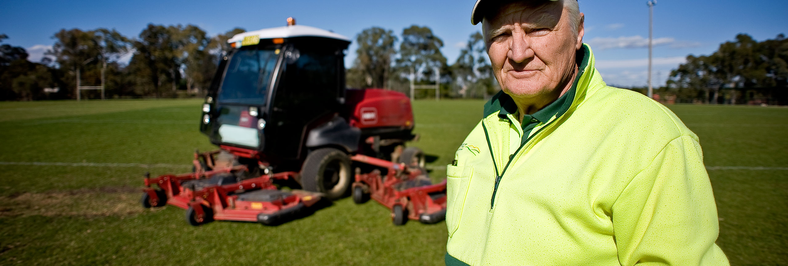 Council officer standing in front of a tractor in a park